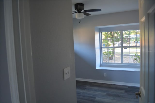 unfurnished room featuring ceiling fan, a wealth of natural light, and dark hardwood / wood-style flooring