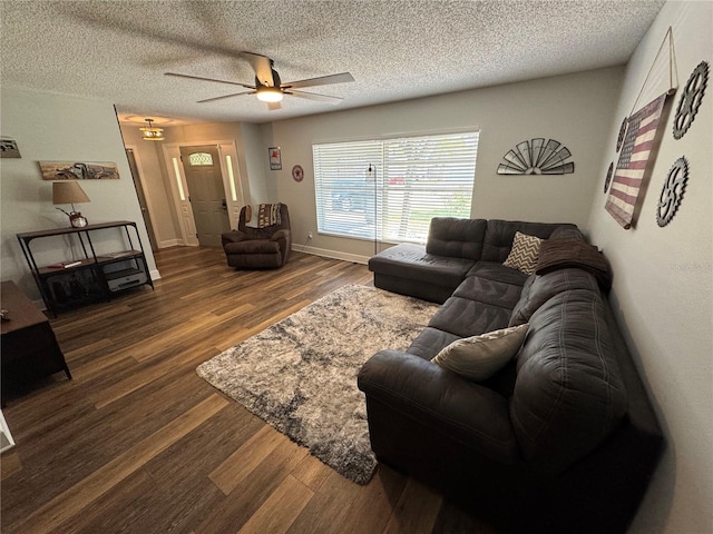 living room with ceiling fan, dark hardwood / wood-style flooring, and a textured ceiling