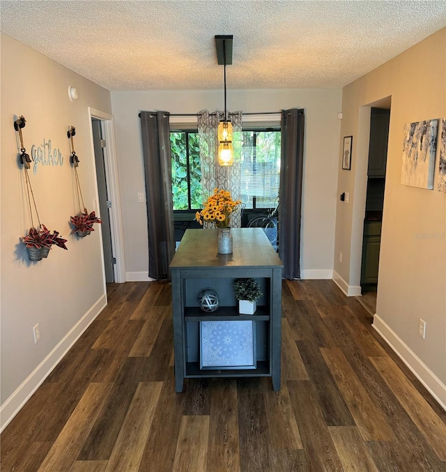 kitchen featuring a textured ceiling, dark hardwood / wood-style floors, and hanging light fixtures