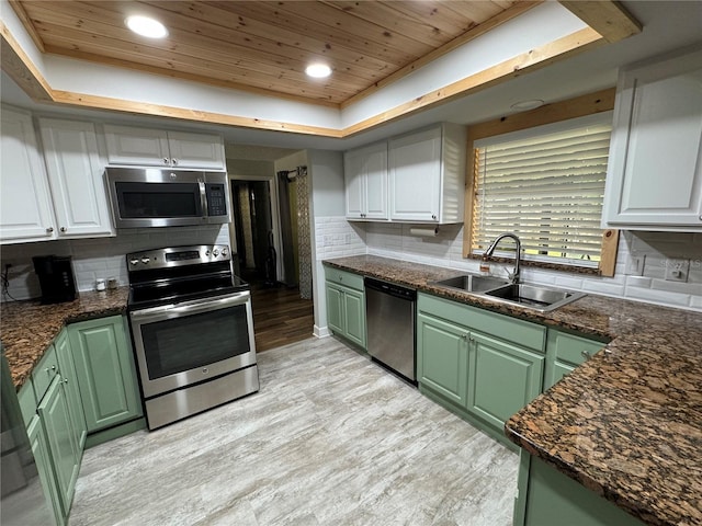 kitchen featuring white cabinets, a raised ceiling, sink, appliances with stainless steel finishes, and wood ceiling