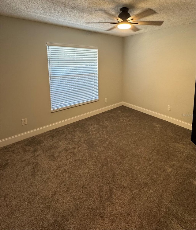 spare room featuring dark colored carpet, a textured ceiling, and ceiling fan