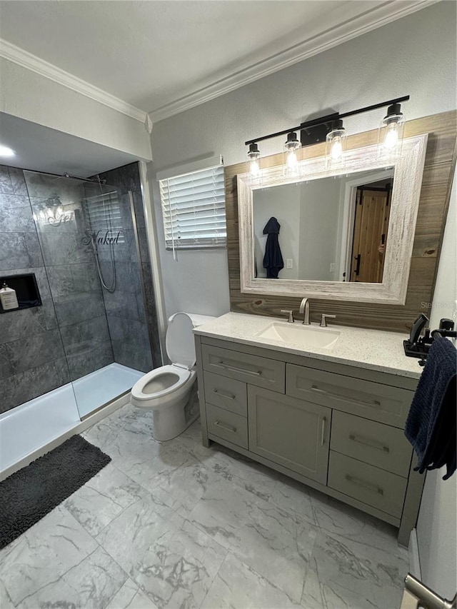 bathroom with a tile shower, vanity, toilet, and crown molding