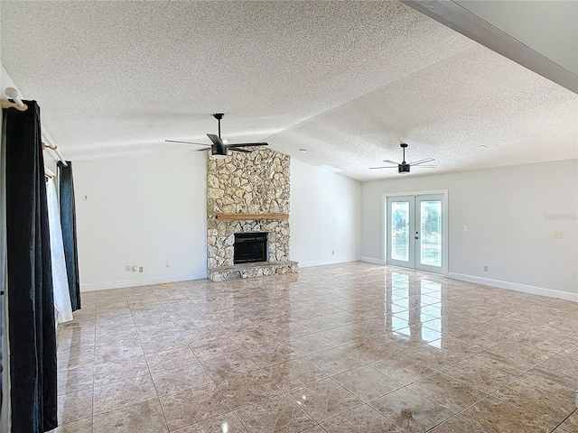 unfurnished living room featuring ceiling fan, vaulted ceiling, a fireplace, and french doors