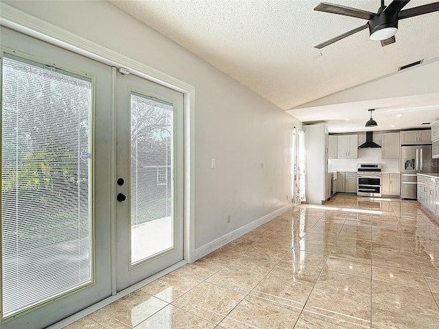 interior space featuring french doors, a textured ceiling, vaulted ceiling, and ceiling fan