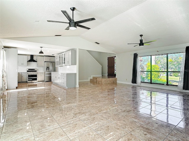 unfurnished living room with a textured ceiling, ceiling fan, and vaulted ceiling