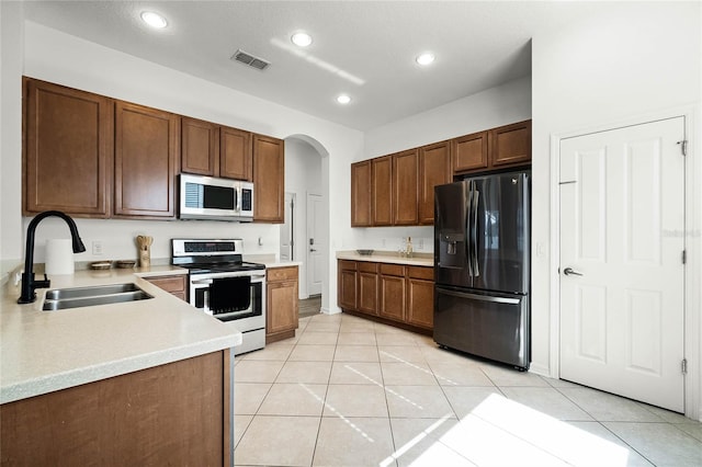 kitchen with light tile patterned flooring, appliances with stainless steel finishes, and sink