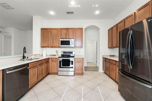 kitchen with light tile patterned floors, sink, and appliances with stainless steel finishes