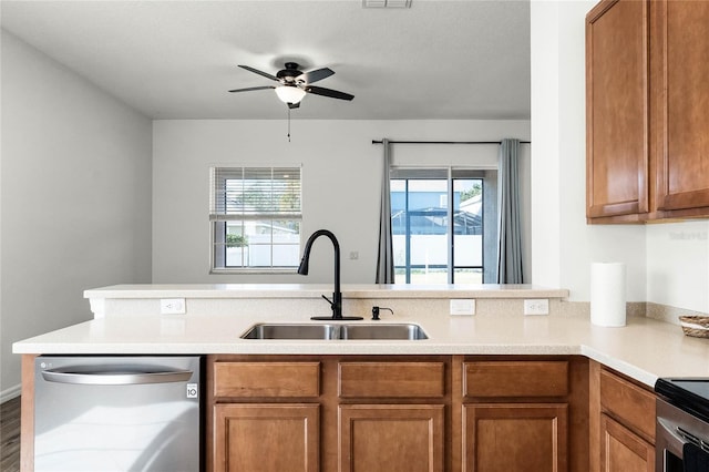 kitchen with kitchen peninsula, sink, stainless steel appliances, and plenty of natural light