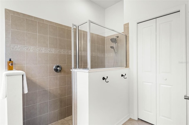 bathroom with tile patterned flooring and a tile shower