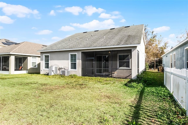 back of house featuring a lawn, central air condition unit, and a sunroom