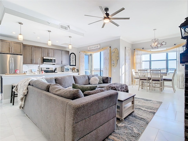 living room featuring ceiling fan, a healthy amount of sunlight, light tile patterned floors, and ornamental molding