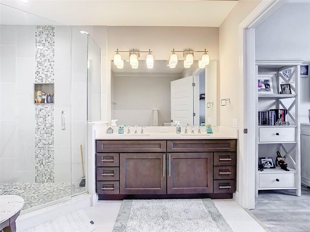 bathroom featuring a shower with door and vanity