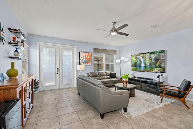 living room with french doors, visible vents, light tile patterned flooring, ceiling fan, and a textured ceiling