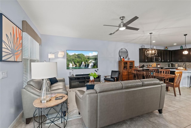 living room with sink, ceiling fan with notable chandelier, and light tile patterned floors