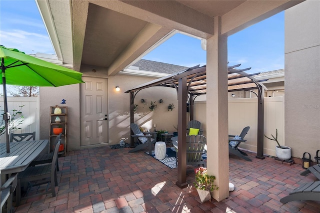 view of patio featuring outdoor dining space, fence, and a pergola