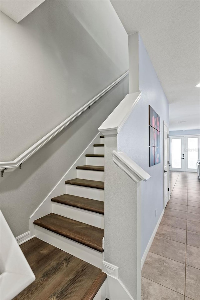 staircase with tile patterned flooring and french doors