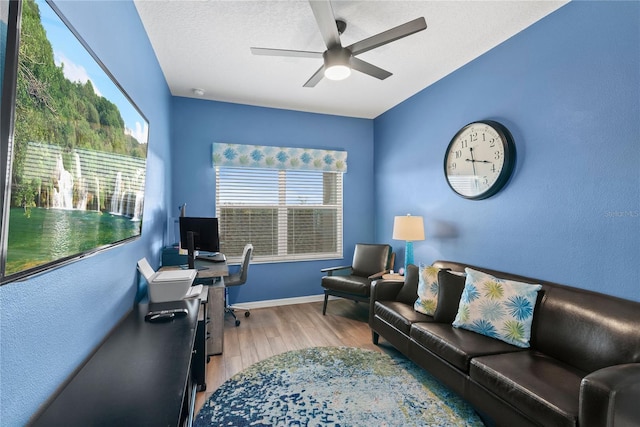 office area featuring ceiling fan, light hardwood / wood-style flooring, and a textured ceiling