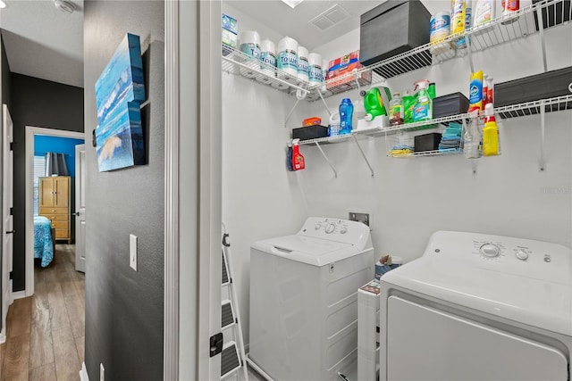 washroom featuring laundry area, washer and clothes dryer, and wood finished floors