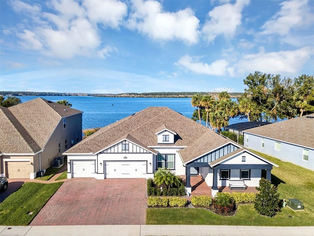 exterior space with a front yard, a garage, and a water view