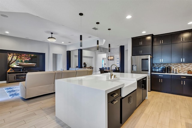 kitchen featuring sink, pendant lighting, an island with sink, and dishwasher