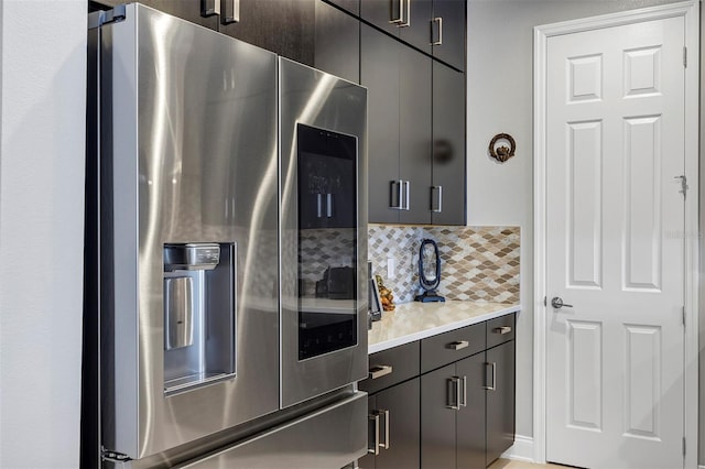 kitchen with stainless steel fridge with ice dispenser and backsplash