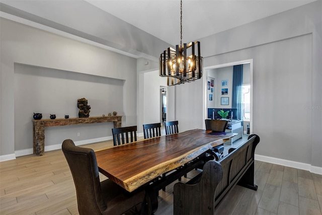 dining room with light wood-type flooring and a chandelier