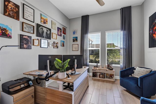 office space with ceiling fan, light wood-type flooring, and a healthy amount of sunlight