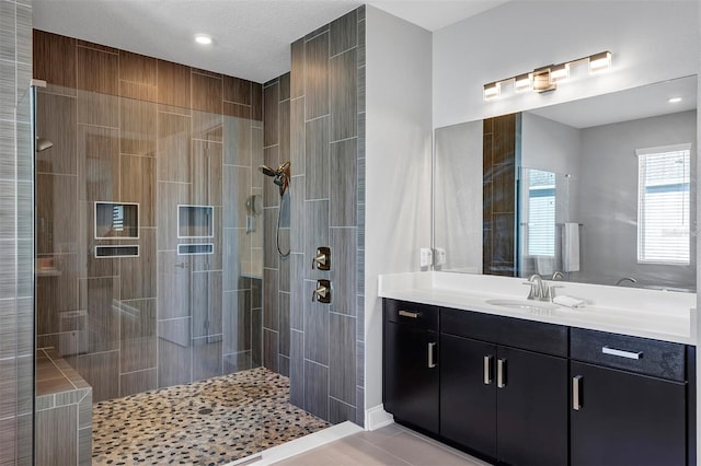 bathroom featuring tiled shower, vanity, and tile patterned floors