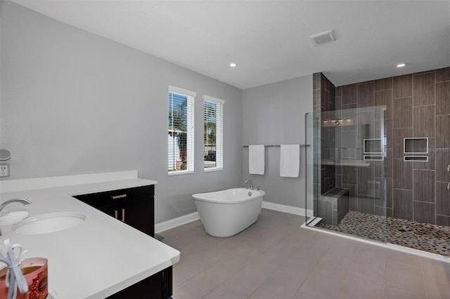 bathroom featuring tile patterned floors, independent shower and bath, and vanity