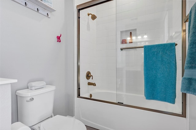 bathroom featuring enclosed tub / shower combo and toilet