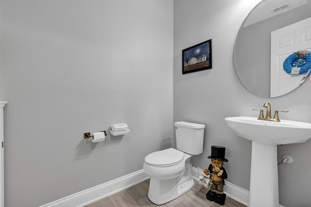 bathroom with toilet and hardwood / wood-style flooring