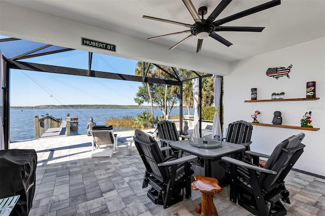 view of patio featuring a water view, a lanai, grilling area, ceiling fan, and a boat dock