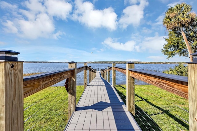 dock area with a yard and a water view