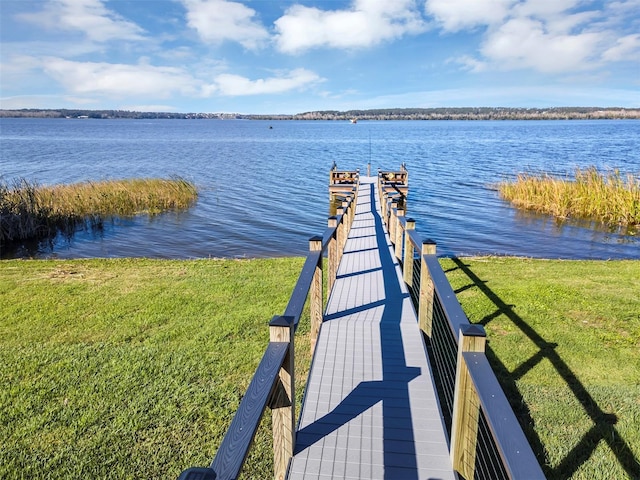 view of dock featuring a lawn and a water view