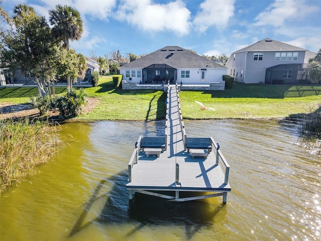 view of dock with a water view and a lawn