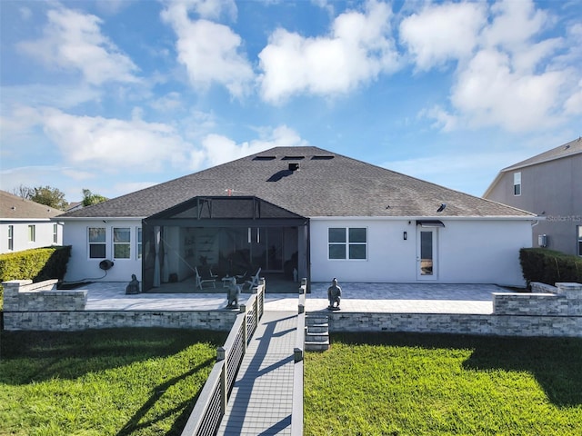 rear view of house with a yard, glass enclosure, and a patio area