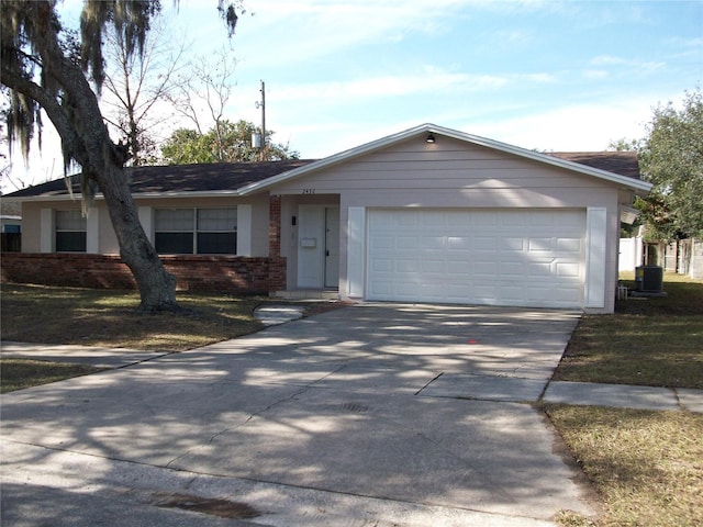 ranch-style house featuring central AC unit, a garage, and a front lawn