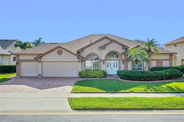 view of front of house with a garage and a front lawn