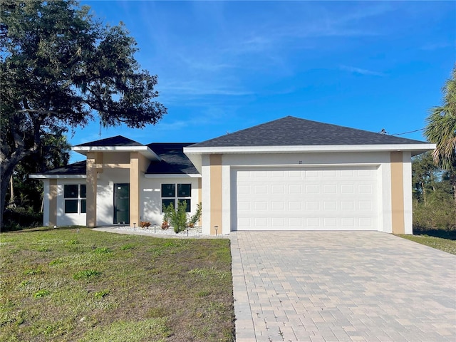 view of front of property featuring stucco siding, an attached garage, decorative driveway, and a front lawn