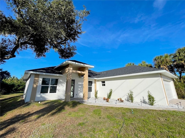 view of front of property with a garage, stucco siding, and a front yard