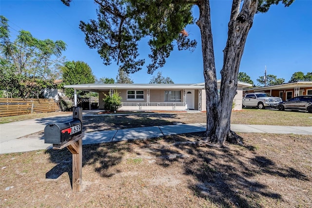 ranch-style home with a porch and a carport