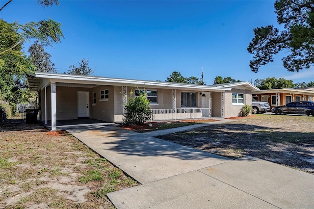 ranch-style home with covered porch and a carport