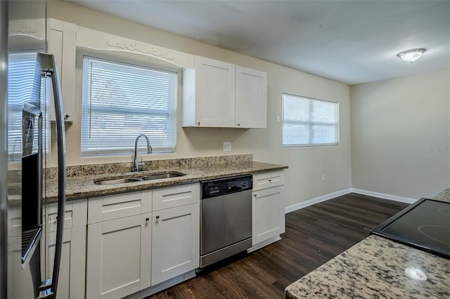 kitchen featuring white cabinetry, stainless steel dishwasher, light stone counters, and sink