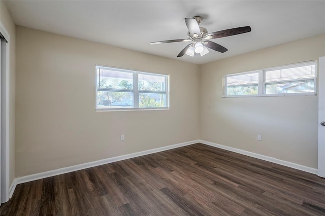 spare room featuring ceiling fan, a healthy amount of sunlight, and dark hardwood / wood-style floors