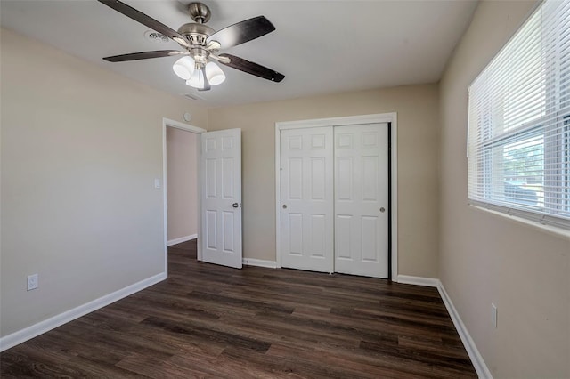 unfurnished bedroom featuring ceiling fan, a closet, and dark hardwood / wood-style flooring