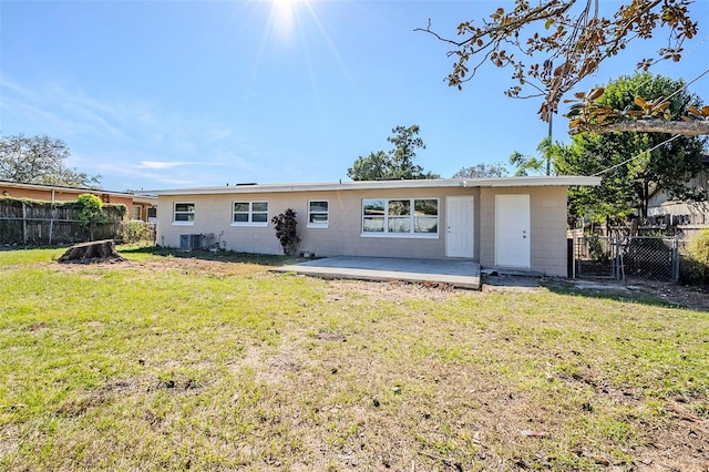 rear view of house with central AC, a patio area, and a yard