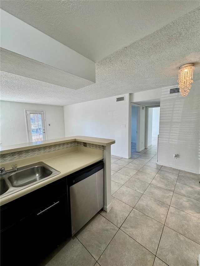 kitchen featuring sink, dishwasher, a textured ceiling, and an inviting chandelier