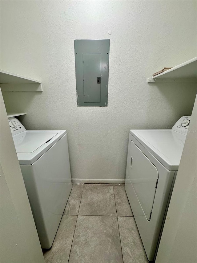 clothes washing area featuring separate washer and dryer, electric panel, and light tile patterned flooring