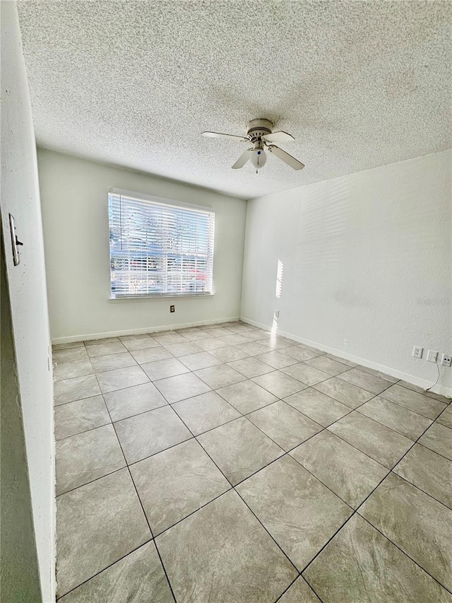 tiled spare room featuring ceiling fan and a textured ceiling