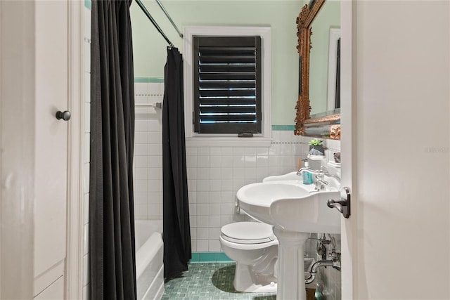 bathroom featuring tile patterned floors, toilet, tile walls, and shower / tub combo with curtain